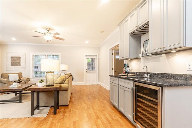 corridor featuring baseboards, ornamental molding, and light wood-style floors