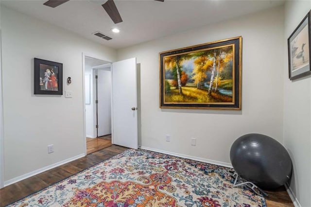 workout room featuring visible vents, baseboards, and wood finished floors