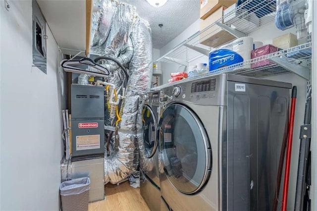 laundry area with a textured ceiling, independent washer and dryer, wood finished floors, and laundry area