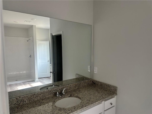 bathroom featuring a stall shower and vanity