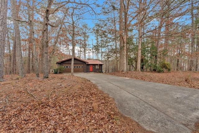 ranch-style home featuring a carport, a garage, and an outbuilding