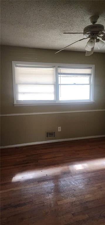 unfurnished room featuring dark wood-type flooring, ceiling fan, and a textured ceiling