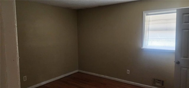 unfurnished room featuring dark hardwood / wood-style floors