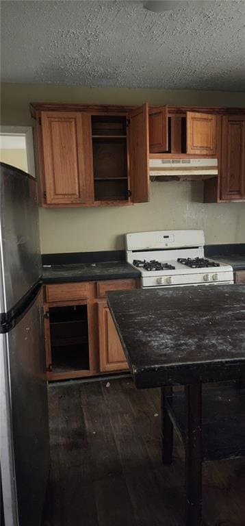 kitchen with dark wood-type flooring, stainless steel fridge, white gas stove, and a textured ceiling