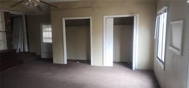 unfurnished bedroom featuring two closets and carpet flooring