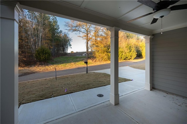 doorway featuring ceiling fan, ornamental molding, and concrete floors