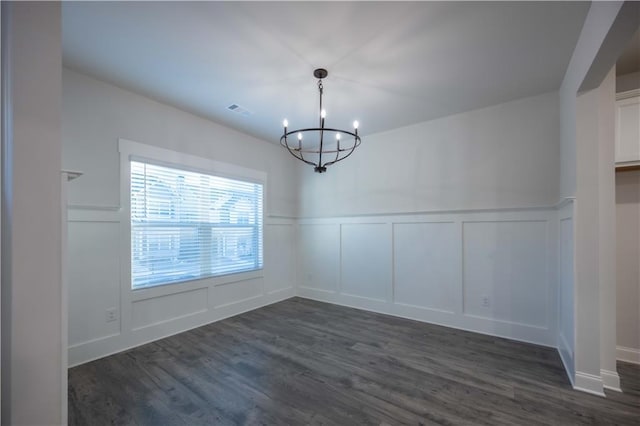 unfurnished dining area with dark hardwood / wood-style flooring and a chandelier