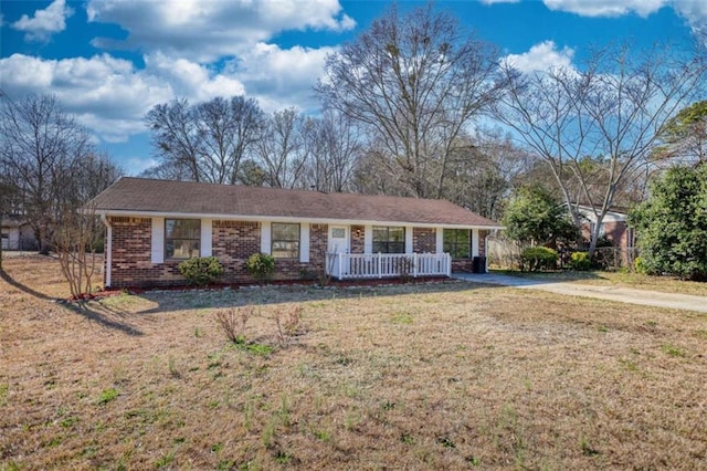 ranch-style home featuring a porch, a front lawn, and brick siding