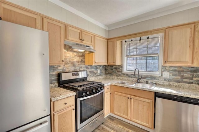 kitchen with appliances with stainless steel finishes, light brown cabinets, and under cabinet range hood