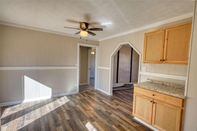 kitchen with dark wood-type flooring, ornamental molding, a textured ceiling, and light brown cabinetry