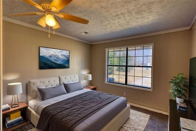 bedroom with ceiling fan, a textured ceiling, carpet flooring, visible vents, and baseboards