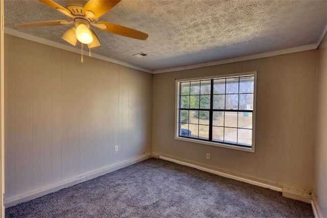 carpeted empty room with baseboards, visible vents, ceiling fan, crown molding, and a textured ceiling