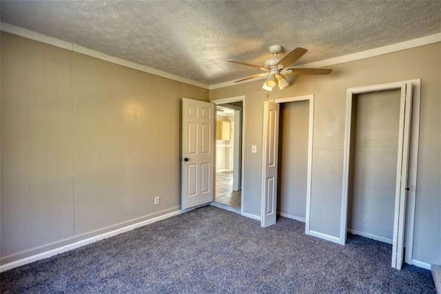 unfurnished bedroom featuring a ceiling fan, dark carpet, a textured ceiling, and baseboards