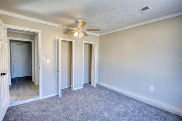 unfurnished bedroom with carpet, visible vents, ceiling fan, a textured ceiling, and baseboards