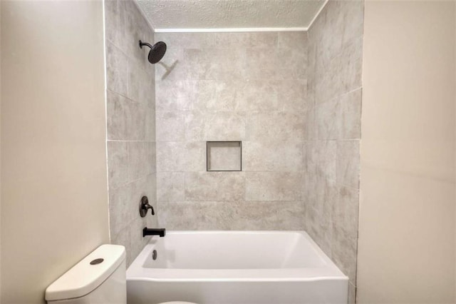 bathroom featuring toilet, tub / shower combination, and a textured ceiling