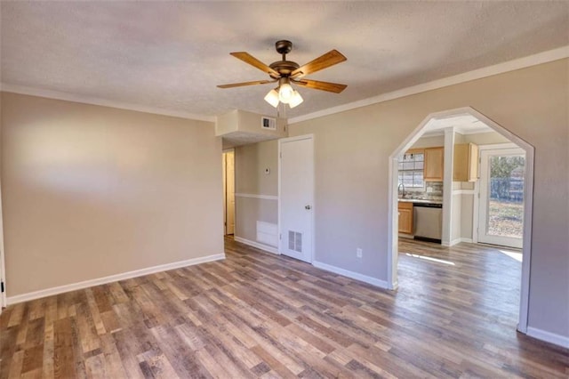 unfurnished bedroom with baseboards, wood finished floors, visible vents, and crown molding