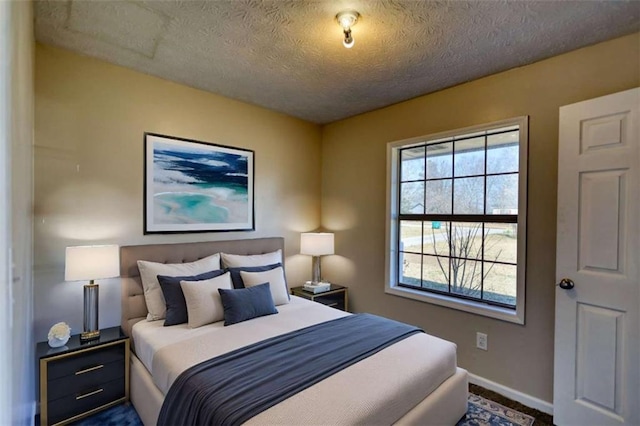 bedroom with a textured ceiling and baseboards