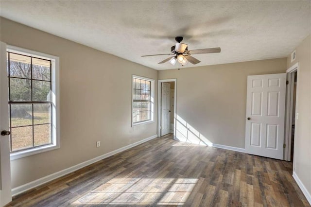 unfurnished bedroom with visible vents, ceiling fan, a textured ceiling, wood finished floors, and baseboards