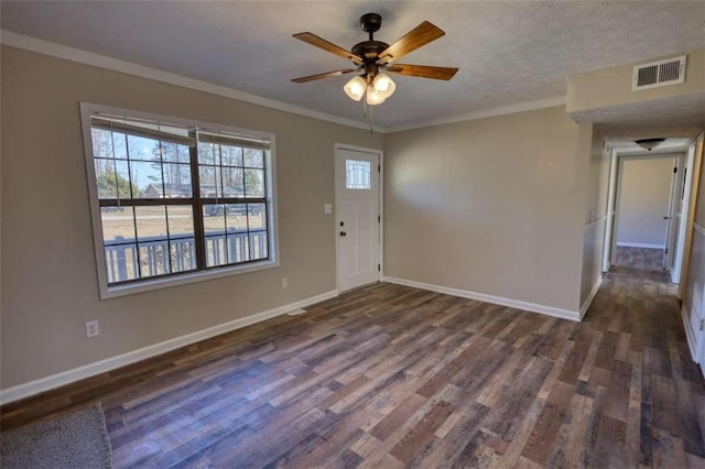 entryway with a textured ceiling, visible vents, baseboards, ornamental molding, and dark wood-style floors