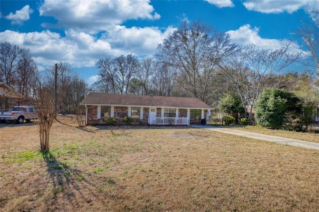 ranch-style house with driveway, brick siding, a porch, and a front yard