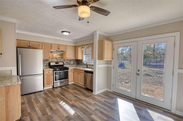 kitchen with french doors, appliances with stainless steel finishes, light brown cabinets, a sink, and under cabinet range hood