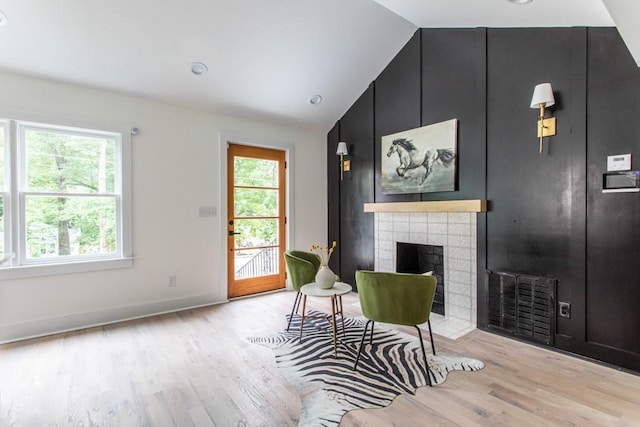 living area with light wood-type flooring, a healthy amount of sunlight, and a fireplace