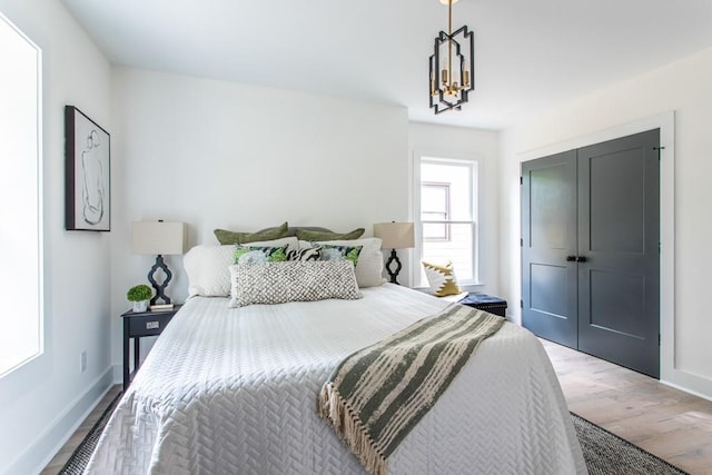 bedroom with a closet, hardwood / wood-style floors, and a chandelier