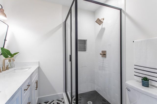 bathroom featuring toilet, vanity, and an enclosed shower