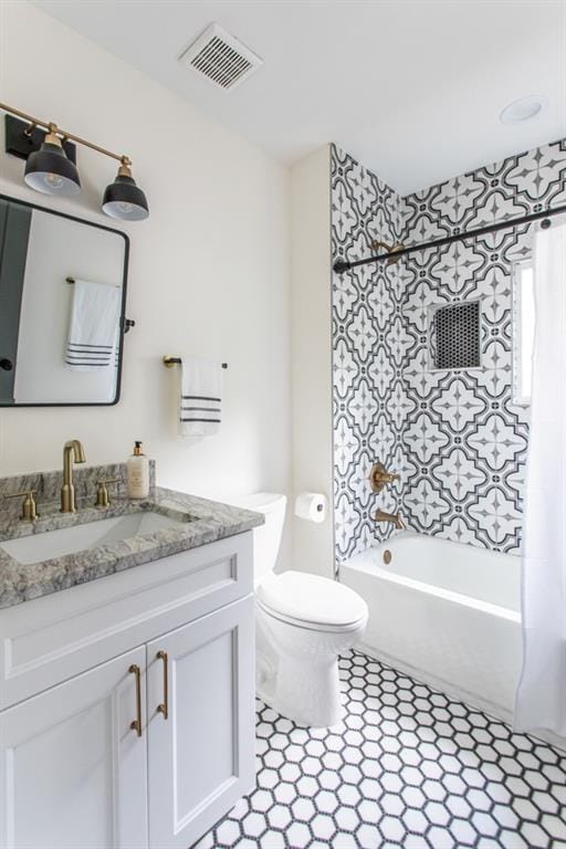 full bathroom featuring tile flooring, toilet, vanity, and shower / bath combo