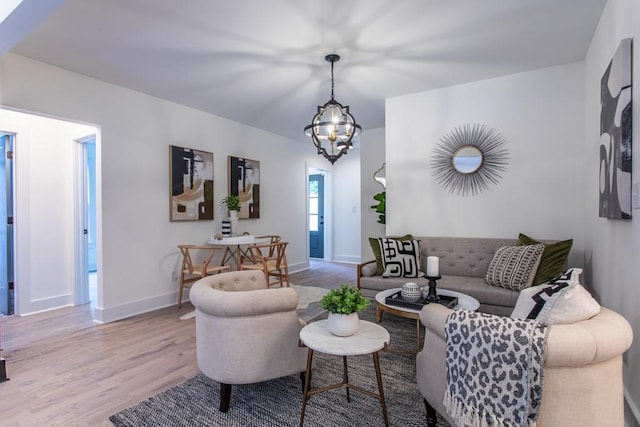 living room featuring an inviting chandelier and light wood-type flooring