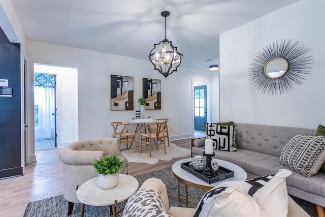 living room featuring an inviting chandelier and light hardwood / wood-style floors