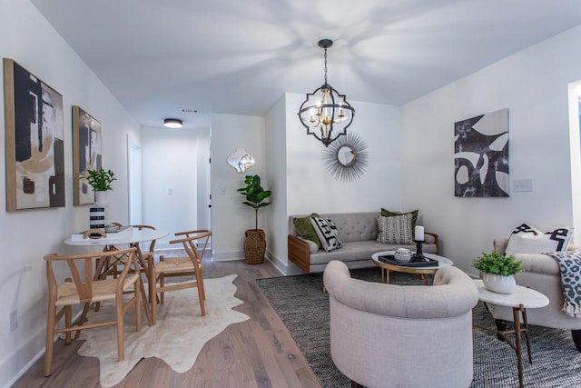 living room featuring an inviting chandelier and light hardwood / wood-style flooring