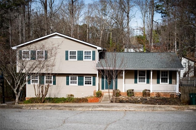 tri-level home with a shingled roof and covered porch