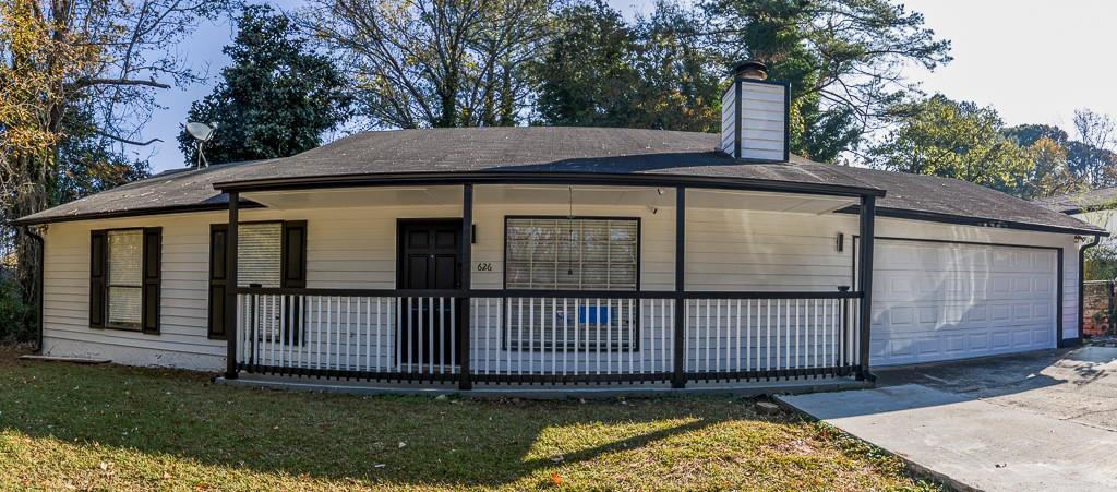 exterior space with covered porch, a garage, and a front lawn