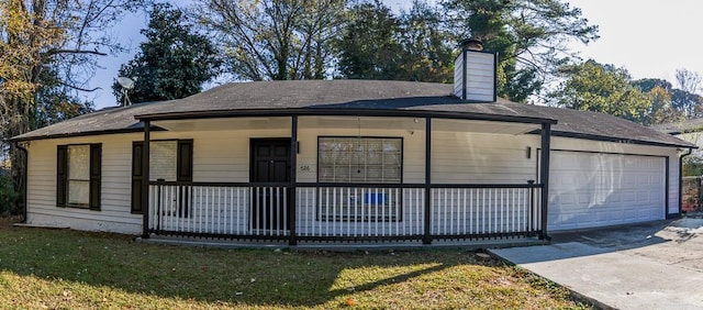 exterior space with covered porch, a garage, and a front lawn