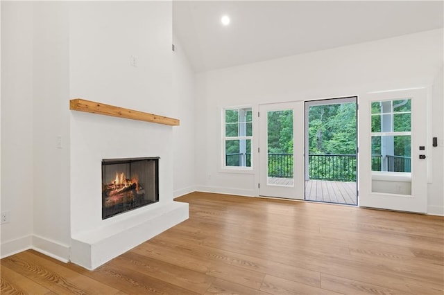 102-A S Cay Dr, Milledgeville, GA 31061 - unfurnished living room featuring a lit fireplace, wood finished floors, healthy amount of natural light, baseboards, and high vaulted ceiling