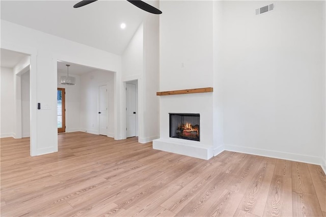 102-A S Cay Dr, Milledgeville, GA 31061 - unfurnished living room featuring light wood-style floors, a lit fireplace, a ceiling fan, baseboards, and high vaulted ceiling