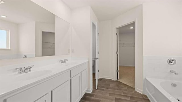 1139 Blue Juniper Cir, Loganville, GA 30052 - full bath with a spacious closet, wood tiled floor, a sink, and a washtub