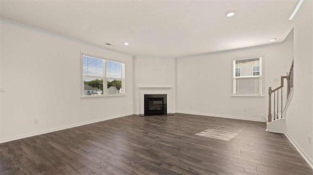 1139 Blue Juniper Cir, Loganville, GA 30052 - unfurnished living room with a glass covered fireplace, baseboards, recessed lighting, stairway, and dark wood finished floors