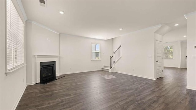 1139 Blue Juniper Cir, Loganville, GA 30052 - unfurnished living room with crown molding, a fireplace with raised hearth, visible vents, stairs, and dark wood-style floors