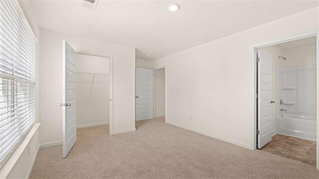 1139 Blue Juniper Cir, Loganville, GA 30052 - unfurnished bedroom featuring a closet, ensuite bathroom, light colored carpet, and baseboards
