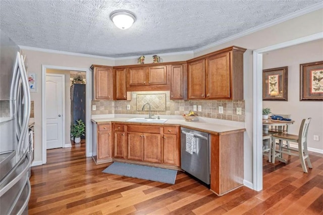 42 Hummingbird Ct, Jefferson, GA 30549 - kitchen with stainless steel appliances, a sink, light wood-style floors, light countertops, and crown molding