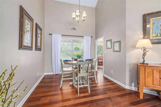 42 Hummingbird Ct, Jefferson, GA 30549 - dining space featuring dark wood-style floors, baseboards, a towering ceiling, and a chandelier