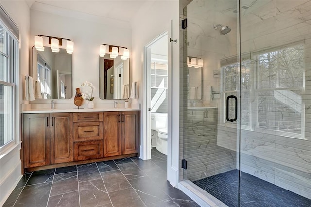 bathroom with crown molding, vanity, toilet, and an enclosed shower