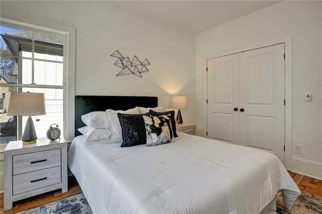 bedroom with dark wood-type flooring and a closet