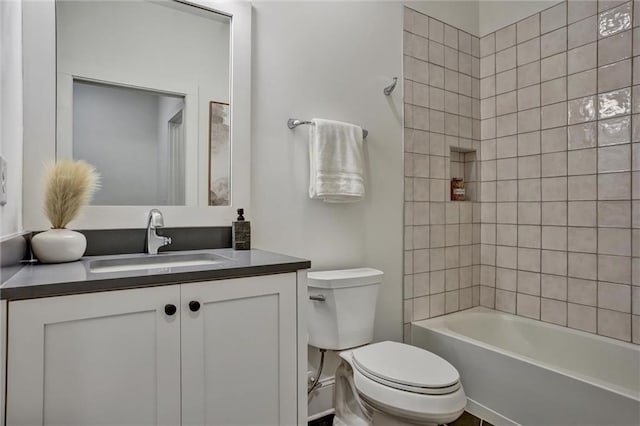 full bathroom with vanity, tiled shower / bath combo, and toilet