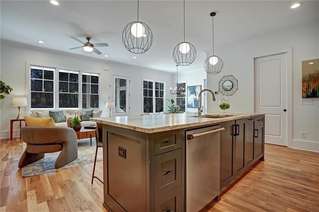 kitchen featuring sink, light stone counters, decorative light fixtures, a center island with sink, and dishwasher