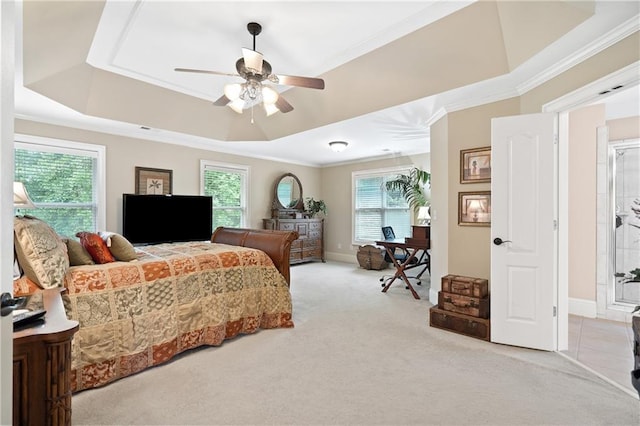 carpeted bedroom with ceiling fan, a tray ceiling, ornamental molding, and baseboards