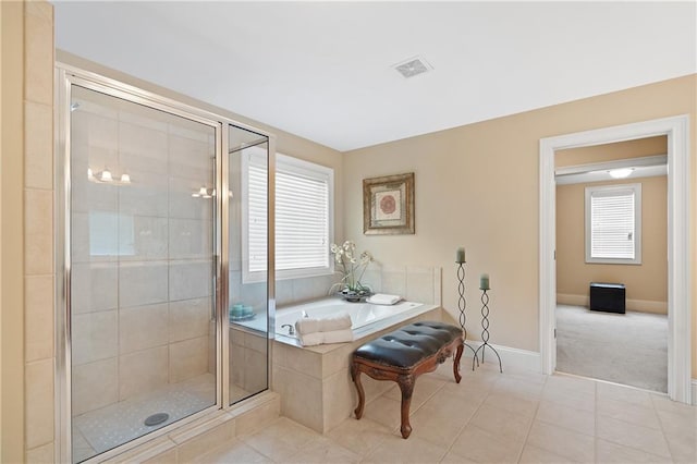 full bathroom with tile patterned flooring, a shower stall, a bath, baseboards, and visible vents