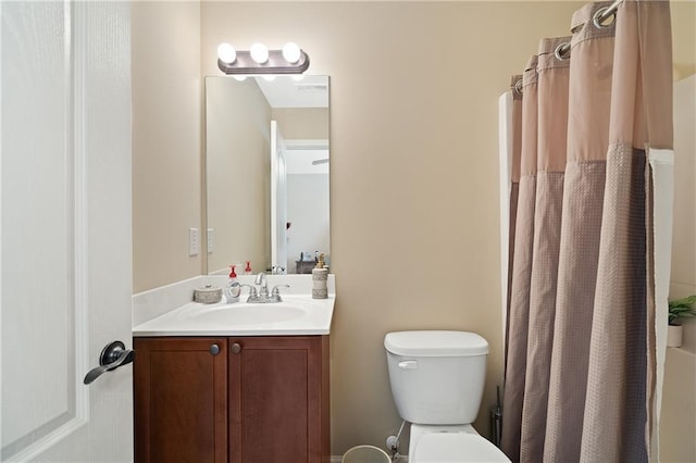 bathroom featuring toilet, curtained shower, and vanity